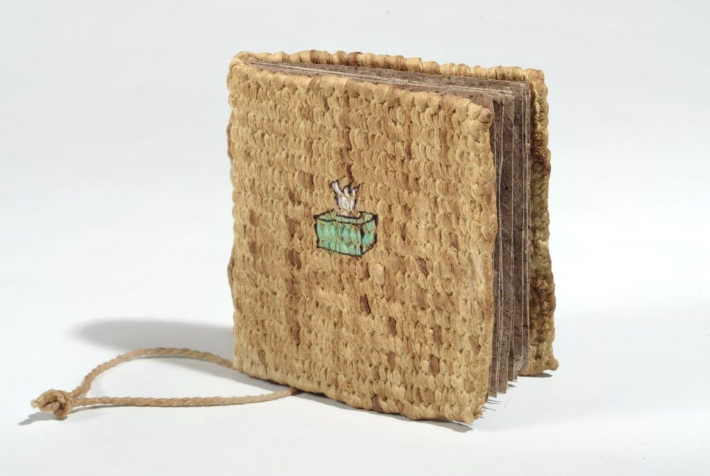 The story of a book (2011). Pen and pencil comic on handmade slippery elm paper, slippery elm-dyed hanji yarn corded and woven, kon'nyaku-covered covers. 3.25 x 3.25 x 0.5". MIA.