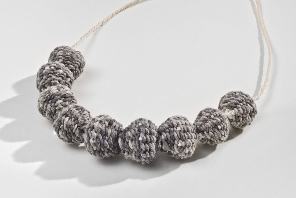 Grey bead necklace (2012). Hanji, calligraphy ink (9 beads). 1.2" diameter each. Private collection.
