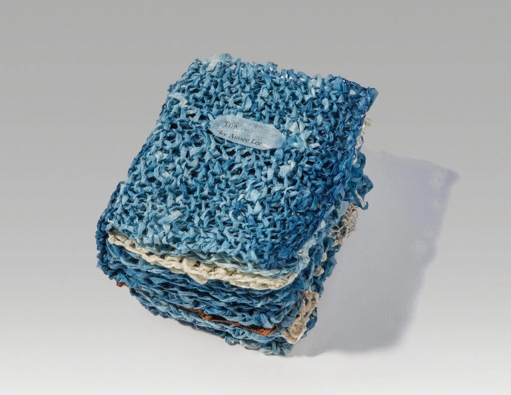 Trip (knitted version) (2025). Indigo, persimmon juice, letterpress, and pen on hanji. 4.5 x 3.75 x 3” closed, 8.5” wide open. Variable edition of 18.